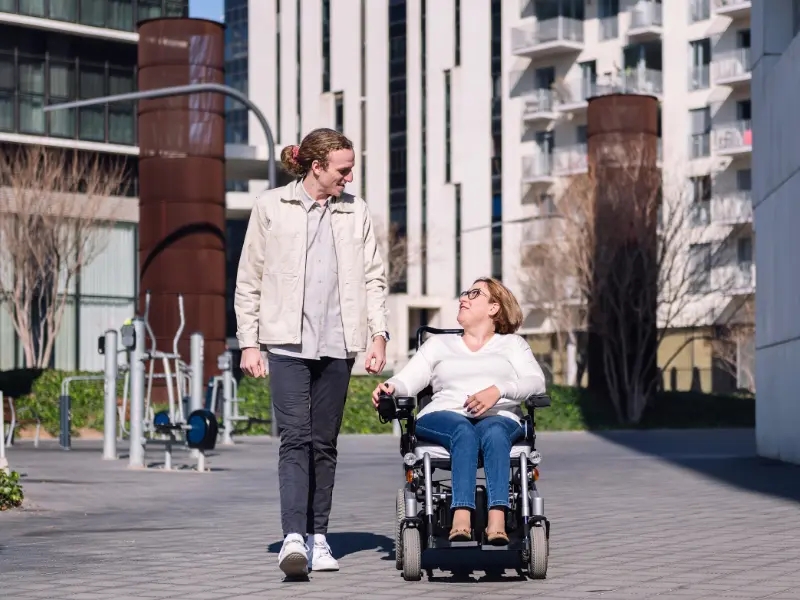 Disabled woman in wheelchair outside with a friend