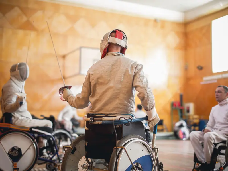 Disabled friends in wheelchairs in fencing class