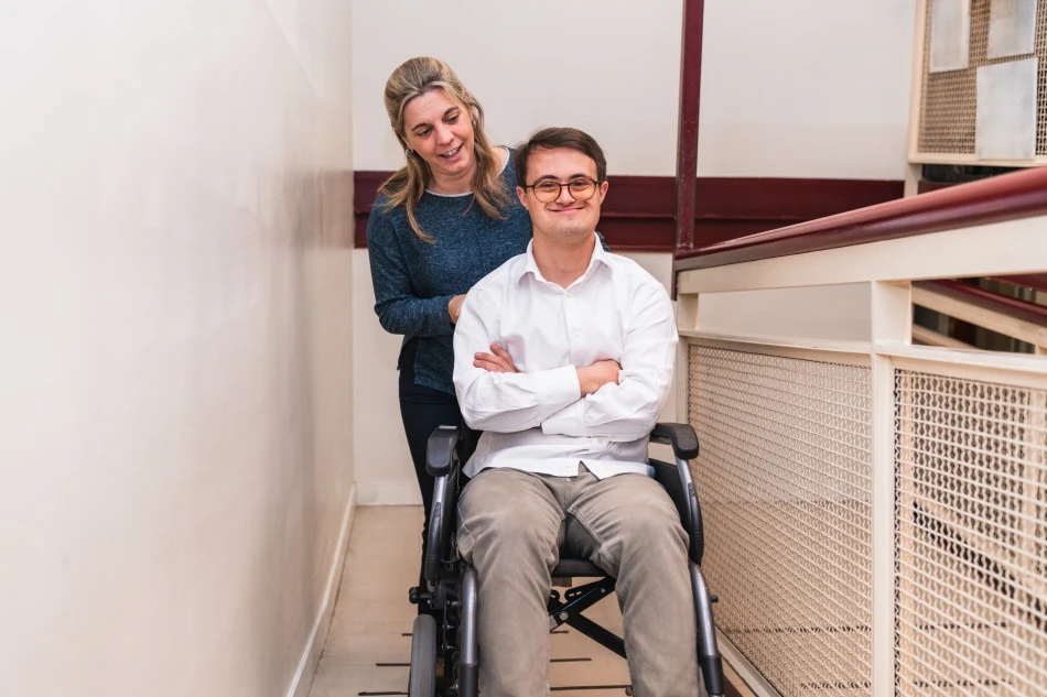 Support worker pushing disabled man in wheelchair